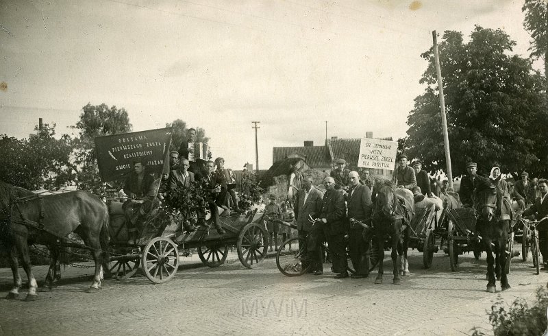 KKE 3709.jpg - Zbiory. Od  lewej: Adam Gutkowski, x, Jan Wencław (zam. Jemiołowo, ur. 10 I 1925 r. przybył z Zastawia gm. Ludwikpol (Ukraina)), Lewandowski (wójt), Sówiński (ojciec ?), pracownik gminy (?), Sówinski Józef (syn), Burmistrz (NN),  Wacław Sietlicki, Tadeusz Świderski (na lewo od białego transparentu w berecie), pracownik gminy (NN), Władysław Jasiński, Mieczysław Janana, Mieczysław Zjadlak, x, Józef Resiak (na prawo od słupa),Marianna Dorosz, Stefan Krawczyk, x, Olsztynek, ul. Grunwaldzka, lata 1956-58 r.